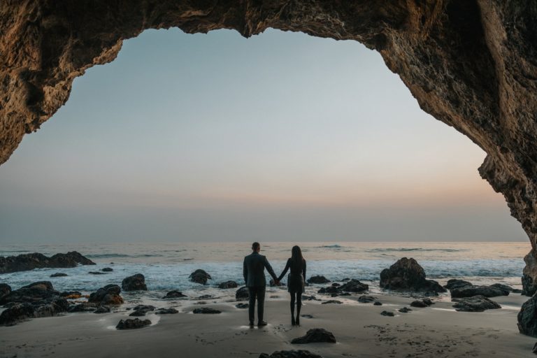 a couple of people walking on a beach