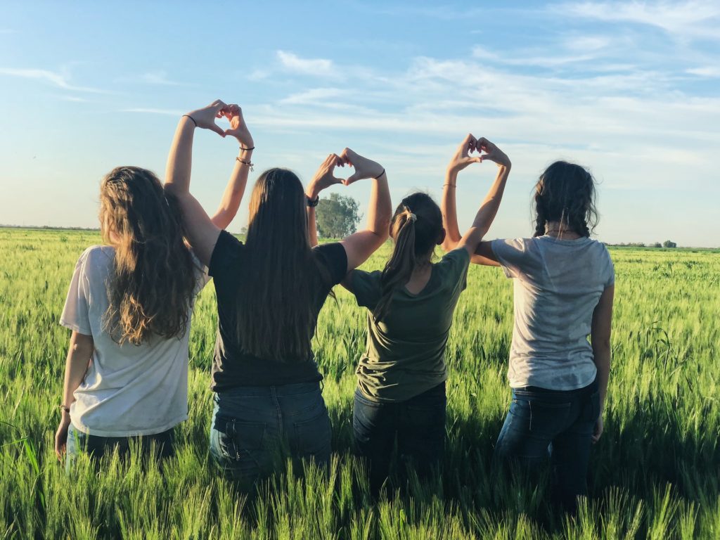 a group of people holding up a peace sign in a field