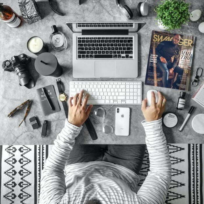 a person sitting in front of a computer with a lot of clutter